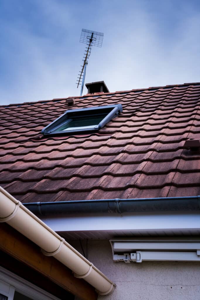 Fenêtre de toit sur toiture en tuiles rouges